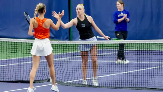 Reece Carter shakes hands with an opponent from Illinois at the net