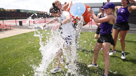 Head coach Robin Stephenson gets dumped with water by Reece Carter and Zehra Suko following a 4-1 win over Penn State at the Big Ten Tournament