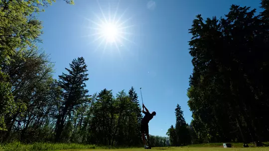 Finn Koelle hits a tee shot into the sun at Pumpkin Ridge Golf Club