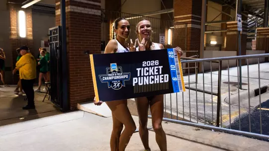 Julia David-Smith and Chloe Thomas pose with a Ticket Punched sign at NCAA Prelims