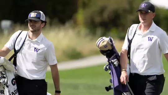 Brock Maulding and Finn Koelle walk with their bags to the green