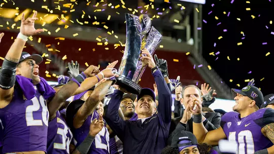 Chris Petersen holds the 2016 Pac-12 Championship trophy following the win over Colorado
