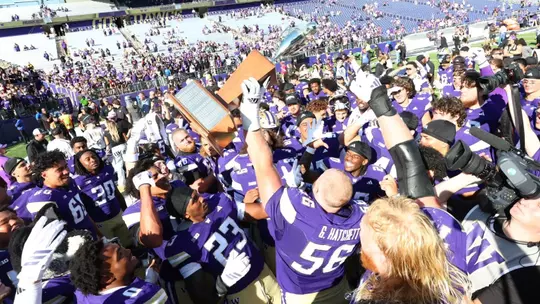 UW football hoisting Boeing Apple Cup trophy
