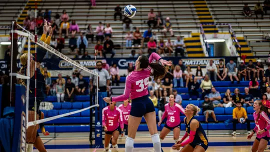 Elena Vukmanov going for a kill against ETSU in UTC's pink jerseys