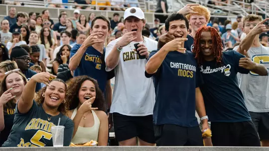 Students stand and flash the Power C hand sign to mug for the camera at Finley Stadium