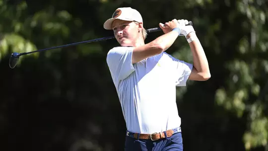 Evan Rogers holds his finish as he follows his tee shot