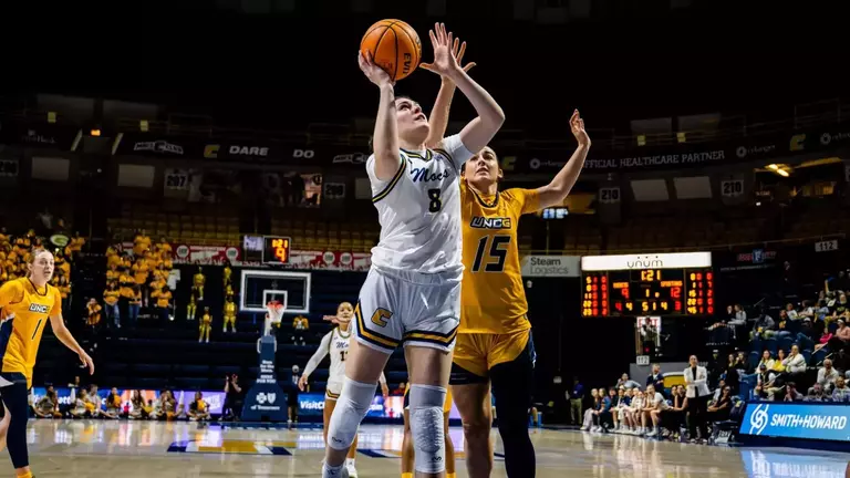 Evie Bruce driving to the basket at home against UNCG