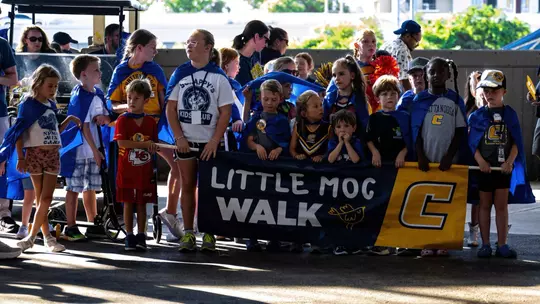 A large number of 12 and under Mocs fans gather behind their Little Moc Walk banner to lead the spirit parade at football tailgating.