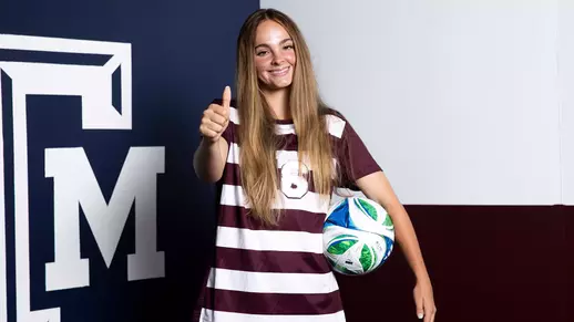 Trinity Buchanan gives a Gig 'em and flashes a smile during her media day portrait shoot