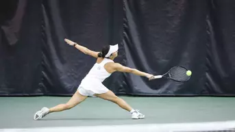 Violeta Martinez reaching to hit the ball.