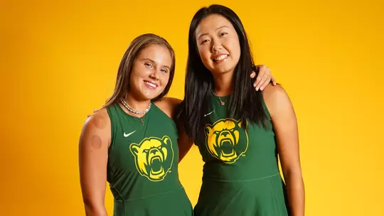 Zuzanna Kubacha and Na Dong post in front of gold background