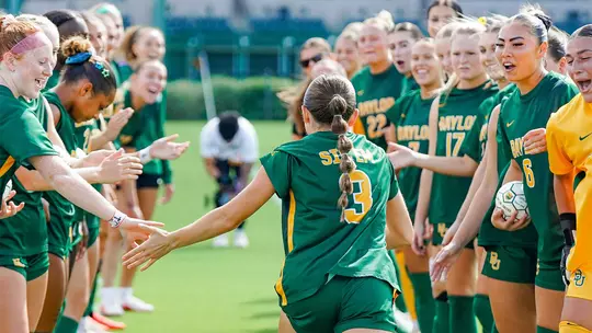 Natalie Vatter runs through team huddle during lineup announcements at home against K-State
