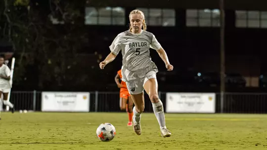 Lauren Omholt dribbles the soccer ball up Betty Lou Mays Field against Marquette