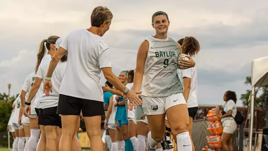 Callie Conrad high fives Michelle Lenard in starting lineup announcement