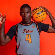 Kashie Natt poses for a photo in a grey Oklahoma State jersey against an orange background