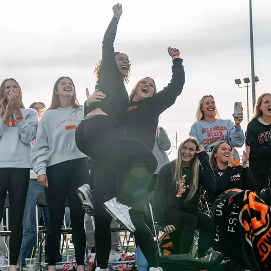 Members of the Oklahoma State softball team react to being selected to host a 2026 NCAA Regional.