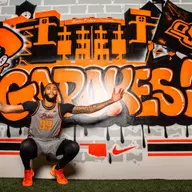 Jordan Burks poses for a picture in front of an OSU mural