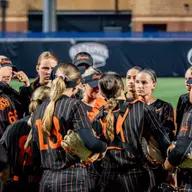 The Oklahoma State softball team gathers during its Big 12 Tournament semifinal game against Arizona State.