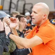 Head coach Steve Lutz high-fives students after a win in Gallagher-Iba Arena