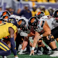A photo of the line of scrimmage just before the snap in a football game played between Oklahoma State and West Virginia.