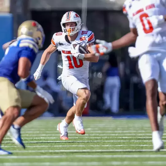 Oklahoma State wide receiver Wyatt Young eludes a tackler from Tulsa