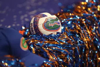 A volleyball with the Florida Gators logos sits in between orange and blue pompoms.