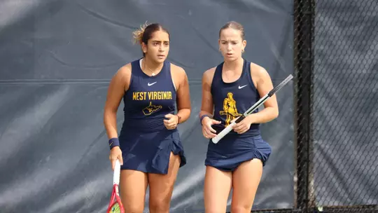 Sorana Matis and Sosanna Malaak talk after a point during a doubles match