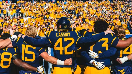 West Virginia fans and players sing "Take Me Home, Country Roads" after West Virginia's win against Cincinnati on Oct. 17, 2026.