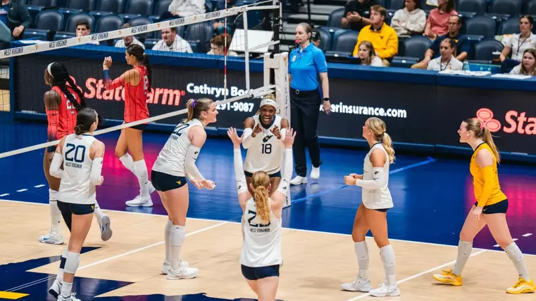 WVU Volleyball celebrates as they defeat Arizona on Oct. 23