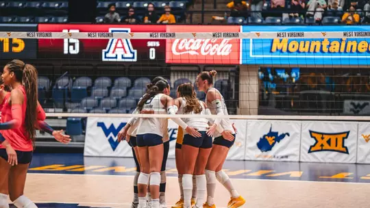 WVU Volleyball team huddles before a point against Arizona