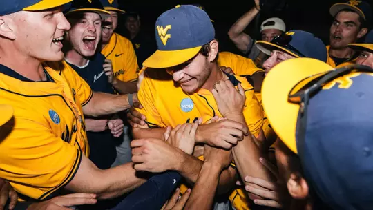 West Virginia players celebrate winning pitcher Ben McDougal's five-inning relief stint in the Mountaineers' 11-9 victory over Kentucky to set up a deciding game five on Monday at Kendrick Family Ballpark in Morgantown, W.Va.
