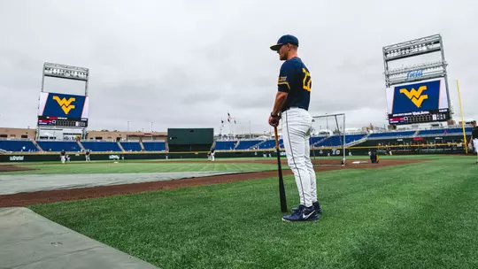 West Virginia coach Steve Sabins observes his team practicing at Charles Schwab Field in Omaha, Nebraska, on the eve of West Virginia's first-ever College World Series game against Troy on Friday, June 12, 2026.