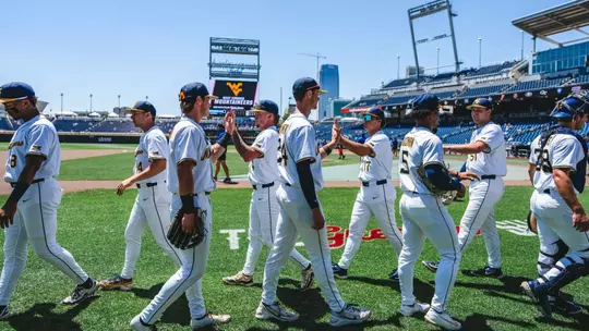 WVU baseball players high five before game against North Carolina