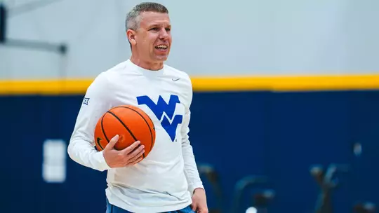 Wet Virginia coach Ross Hodge observes a summer workout inside the Basketball Practice Facility.