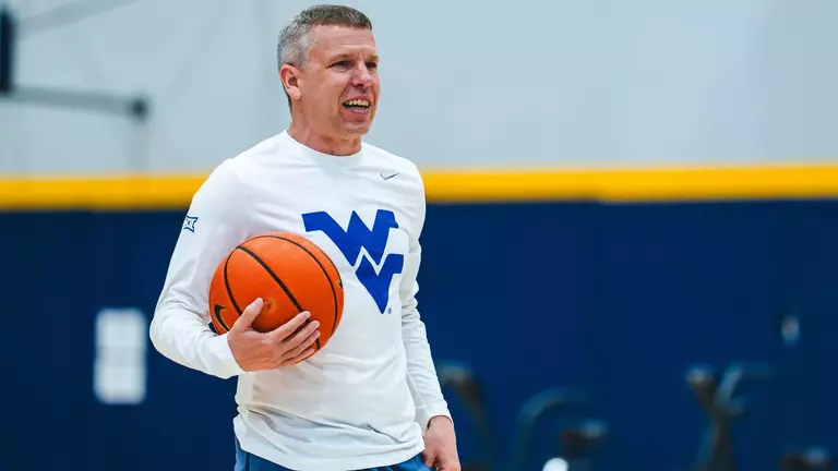 Wet Virginia coach Ross Hodge observes a summer workout inside the Basketball Practice Facility.