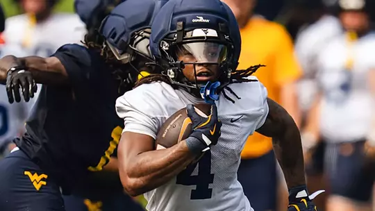 West Virginia's Cam Cook runs the football during a preseason practice on the Steve Antoline Family Practice Field in Morgantown, West Virginia.