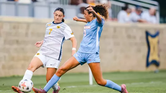 Alexis Pashales of the WVU women's soccer team battles for a ball against a Dayton defender during a match on Aug. 13 in Morgantown.
