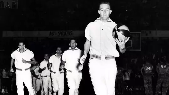 Team captain Willie Akers leads the Mountaineer basketball team out for pregame warmups during a college basketball game at the old Field House in 1960.
