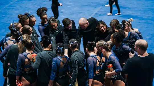 The WVU gymnastics team huddles after a meet at Hope Coliseum in 2026.