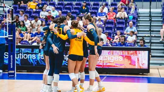WVU Volleyball team huddles after a point