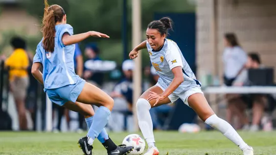 Hannah Heimuli of the WVU women's soccer team battles for a ball during a game against Dayton.
