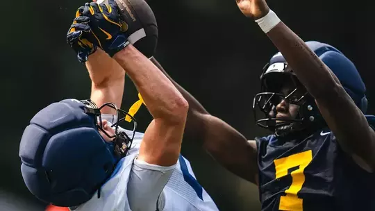 An unidentified West Virginia player makes a catch during fall football practice on the Steve Antoline Family Practice Field on Wednesday, August. 5, 2026. Senior defensive back Chams Diagne (7) is defending.