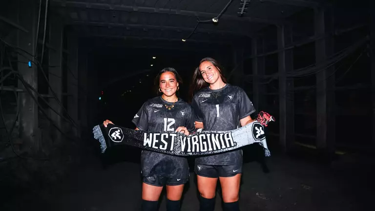 Olivia Shertzer and Bailey Herfurth pose inside a coal mine for the Coal Rush jersey reveal shoot.