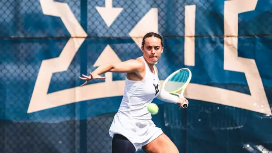 Laura Morillo returns a serve during a tennis match in the 2025-26 season