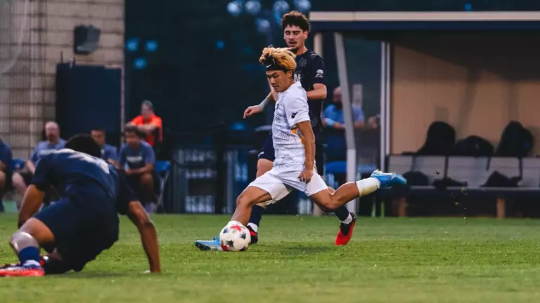 Kanta Ishii kicks the ball against Akron