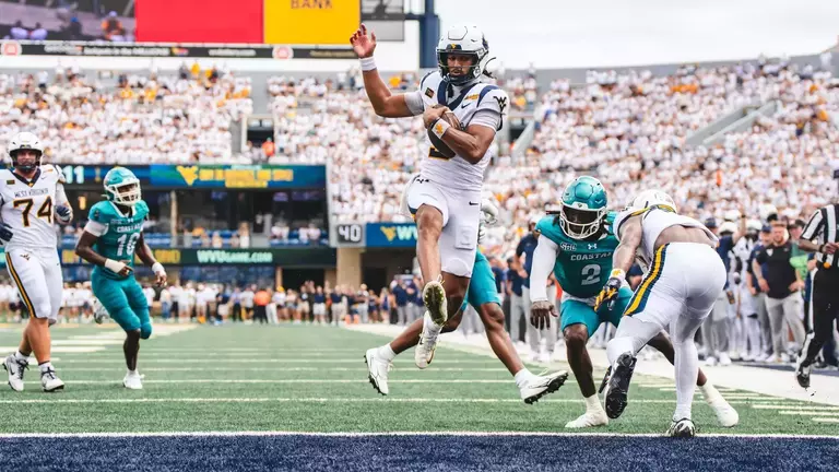 Quarterback Michael Hawkins scores an 11-yard touchdown in the fourth quarter of West Virginia's 31-24 victory over Coastal Carolina at Milan Puskar Stadium.