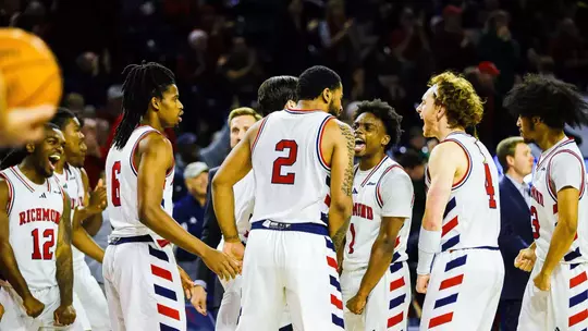 Members of the men's basketball team celebrate at a timeout