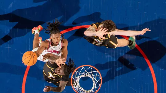 An overhead shot of AJ Lopez making a layup over two VCU defenders