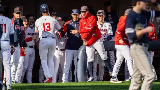 The dugout high-fives Dylan Winebrenner as he returns after scoring