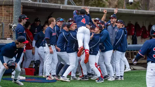 Number four, RJ Johnson Jr jumps into the arms of his teammates to celebrate his home run